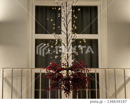 Charming Seasonal Decoration Featuring Berry Garland And Soft Glowing String Lights In Urban Setting 136639197