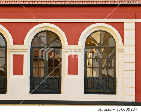 Classic Urban Architectural Features, Red Building With Cream Trim And Arch Windows Reflecting Warm Light 136639237