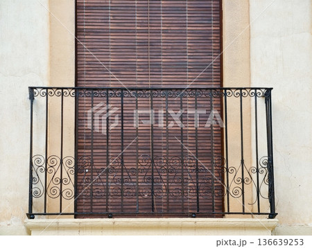 Peaceful Street View Featuring Sunlit Wooden Balcony With Vintage Iron Railing And Soft Shadows 136639253