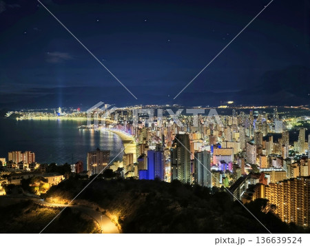 Calm Bay Under Starry Sky, Serene Evening With Still Waters And Distant City Lights Glowing Softly 136639524