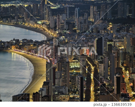 Shoreline Street Illuminated Under Night Sky, Bright Coastal Avenue Reflects City Skyline At Evening Shoreline Street Illuminated Under Night Sky, Bright Coastal Avenue Reflects City Skyline At Evening 136639539