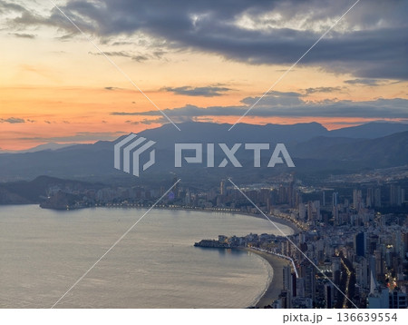 Serene Sunset Over Mountain Coastline, Peaceful Cityscape With Colorful Sky And Distant Peaks Visible 136639554