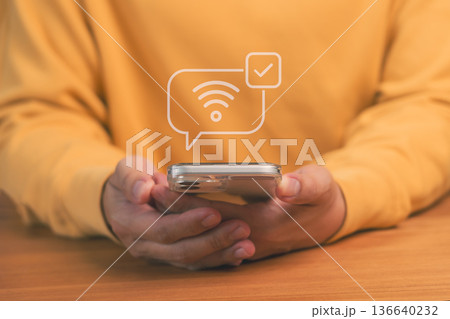 Mobile internet connection concept showing person holding smartphone with wifi signal and check mark icon, symbolizing online access, wireless communication, and digital connectivity technology. Mobile internet connection concept showing person holding smartphone with wifi signal and check mark icon, symbolizing online access, wireless communication, and digital connectivity technology. 136640232