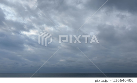厚い雲に覆われた冬の海と静かな水平線 136640406