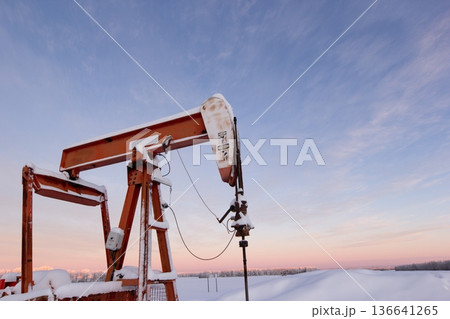Snow Covered Oil Pumpjack at Winter Sunrise Snow Covered Oil Pumpjack at Winter Sunrise 136641265
