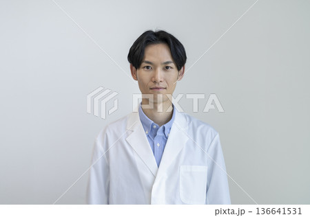 カメラ目線で微笑む白衣を着た30代の男性　白バック　ポートレート 136641531