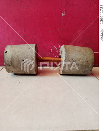 Traditional dumbbells are made from a cement concrete mixture Traditional dumbbells are made from a cement concrete mixture 136641728
