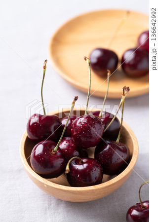 Fresh red cherries with water droplets in a wooden bowl Fresh red cherries with water droplets in a wooden bowl 136642992