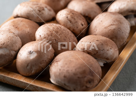 Fresh crimini mushroom or baby bella mushroom on wooden plate Fresh crimini mushroom or baby bella mushroom on wooden plate 136642999