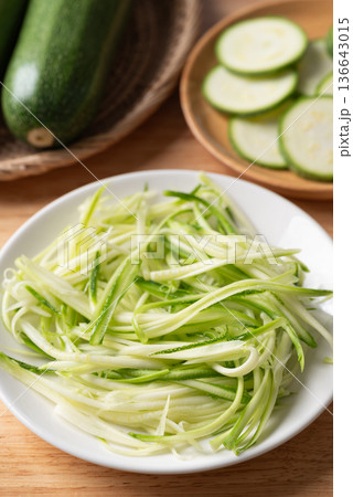 Fresh zucchini noodles (zoodles) in a white plate, prepared for healthy cooking Fresh zucchini noodles (zoodles) in a white plate, prepared for healthy cooking 136643015