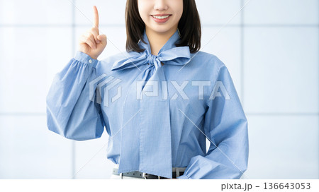人差し指を立てて案内する笑顔の女性・ビジネスウーマン 136643053