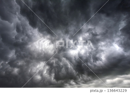 Dramatic dark storm rain clouds black sky background. Dark thunderstorm clouds rainny atmosphere. Meteorology danger windstorm disasters climate. Dark cloudscape storm disaster gloomy gray cloud sky 136643229