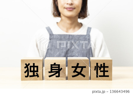 「独身女性」と書かれたブロックとエプロン姿の女性 「独身女性」と書かれたブロックとエプロン姿の女性 136643496