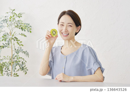 リビングでキウイフルーツを食べる女性 136643526