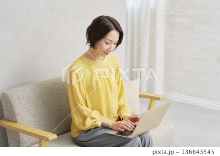リビングでノートパソコン使う女性 136643545