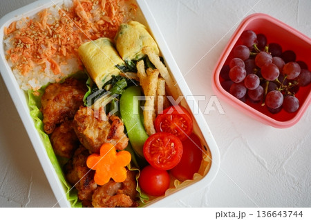 彩り豊かな唐揚げ弁当とぶどう付き栄養バランスの良い手作りランチボックス 136643744
