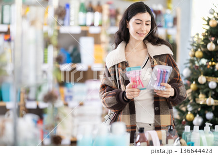 Young woman choosing razor in decorated store 136644428