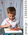 洋服や壁に絵の具が飛び散る自由な男の子のお絵かき 136644430