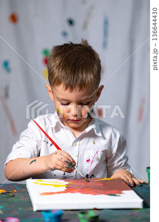 洋服や壁に絵の具が飛び散る自由な男の子のお絵かき 136644430