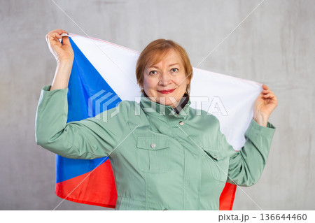 Cheerful senior woman holding flag of Czech Republic Cheerful senior woman holding flag of Czech Republic 136644460