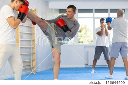 Two men training boxing and kicking in studio 136644600