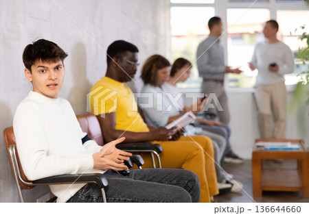 Portrait of an emotional young man sitting waiting Portrait of an emotional young man sitting waiting 136644660