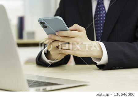 スマホを手にする若い男性の手元のアップ スマホを手にする若い男性の手元のアップ 136646006
