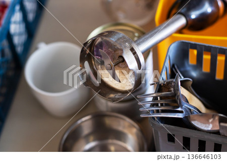 Closeup scene showing utensils drying with warm lighting and reflections present 136646103