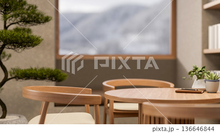 Book and pot plant on round wooden table with armchair aside bonsai tree and window with snowy mount 136646844