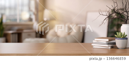 Book and succulent pot and vase on wooden counter table across sofa and frame in blurred living room Book and succulent pot and vase on wooden counter table across sofa and frame in blurred living room 136646859