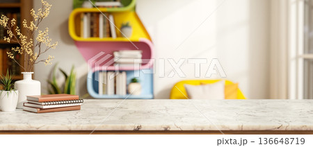 Books and flower vase on marble counter table across colorful wall bookshelf and sofa in living room 136648719