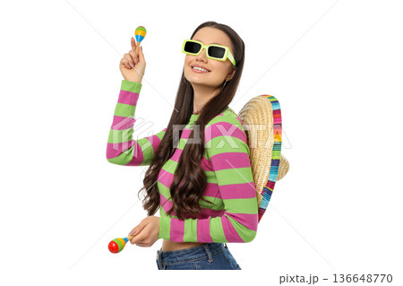 Woman wearing vibrant clothing celebrating with maracas, isolated, PNG 136648770