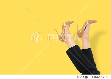 A woman shows off stylish high heel shoes with legs raised A woman shows off stylish high heel shoes with legs raised 136648780