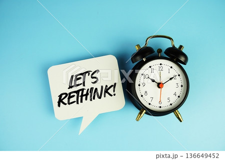 Let's Rethink! text on speech bubble with alarm clock on blue background Let's Rethink! text on speech bubble with alarm clock on blue background 136649452