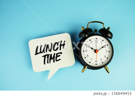 Lunch Time text on speech bubble with alarm clock on blue background Lunch Time text on speech bubble with alarm clock on blue background 136649453