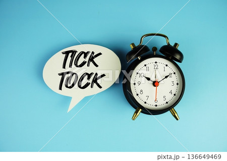 Tick Tock text on speech bubble with alarm clock on blue background Tick Tock text on speech bubble with alarm clock on blue background 136649469