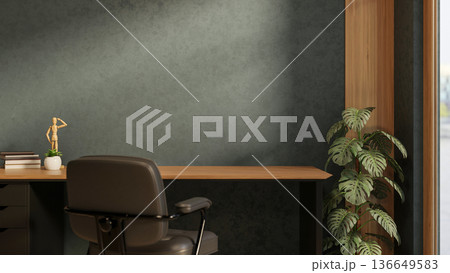Books and figure on wooden table with leather chair and houseplant aside dark green wall in a room. 136649583