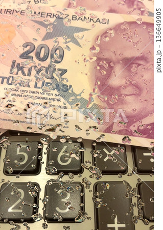 Turkish Lira and Calculator Finance Concept. 200 TRY banknotes on calculator representing Turkish economy, budgeting, and financial planning. 200 Turkish Lira banknotes placed on a black calculator. Turkish Lira and Calculator Finance Concept. 200 TRY banknotes on calculator representing Turkish economy, budgeting, and financial planning. 200 Turkish Lira banknotes placed on a black calculator. 136649905
