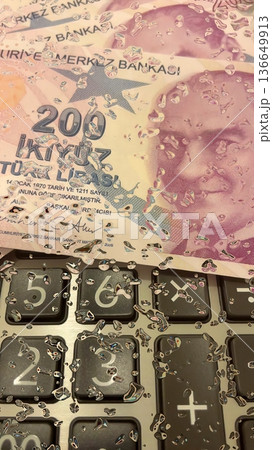 Turkish Lira and Calculator Finance Concept. 200 TRY banknotes on calculator representing Turkish economy, budgeting, and financial planning. 200 Turkish Lira banknotes placed on a black calculator. Turkish Lira and Calculator Finance Concept. 200 TRY banknotes on calculator representing Turkish economy, budgeting, and financial planning. 200 Turkish Lira banknotes placed on a black calculator. 136649913