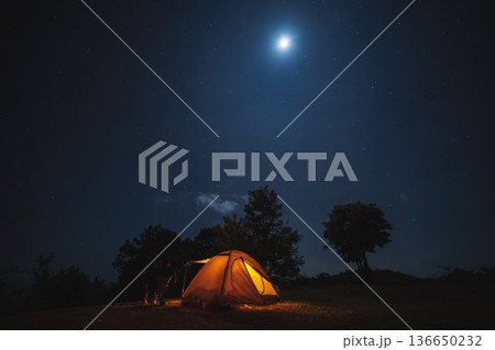 nature traveling with orange camping tent on mountain with milky way and star background 136650232