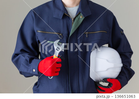 工具とヘルメットを持つ作業服のミドル男性ビジネスマン 136651063