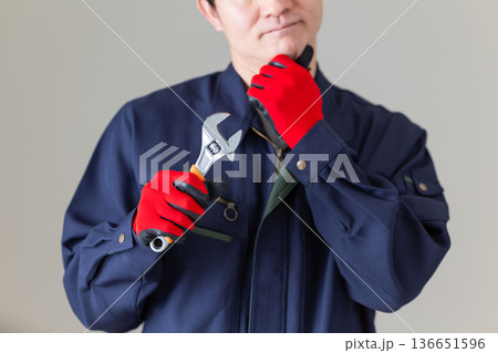 工具を持って悩む作業服のミドル男性ビジネスマン 136651596