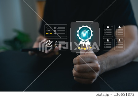 Hand of a person holding a smartphone showing feedback ratings with virtual certification icons, emphasis on digital quality assurance and satisfaction Hand of a person holding a smartphone showing feedback ratings with virtual certification icons, emphasis on digital quality assurance and satisfaction 136651872