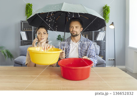 Stressed couple calling for emergency roof repair at home 136652832