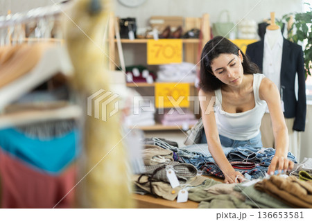 Woman in summer one chooses pants at a sale Woman in summer one chooses pants at a sale 136653581