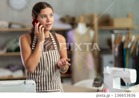 Woman dressmaker talking on mobile phone 136653636