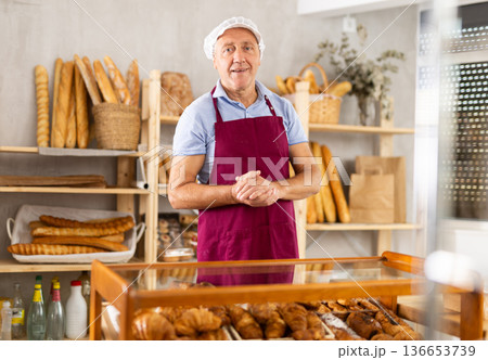 Elderly man seller posing in bakery 136653739