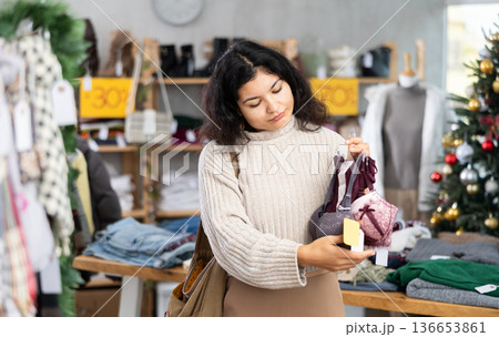 Woman chooses bra in fashionable clothing boutique Woman chooses bra in fashionable clothing boutique 136653861