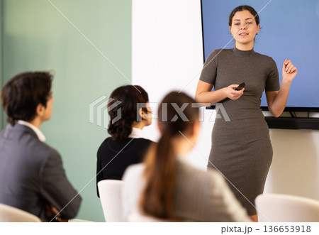 young woman giving a speech to a team of specialists 136653918