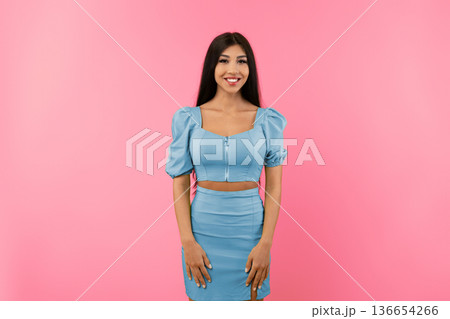 Casual Person Concept. Portrait of smiling young female wearing green dress outfit posing standing isolated on yellow studio background wall. Happy millennial lady looking at camera Casual Person Concept. Portrait of smiling young female wearing green dress outfit posing standing isolated on yellow studio background wall. Happy millennial lady looking at camera 136654266
